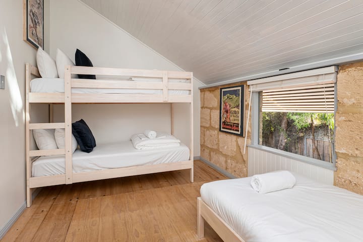 Deleita a los niños en el cuarto dormitorio, con una cama individual y una litera, perfecta para días de diversión y noches de descanso.
