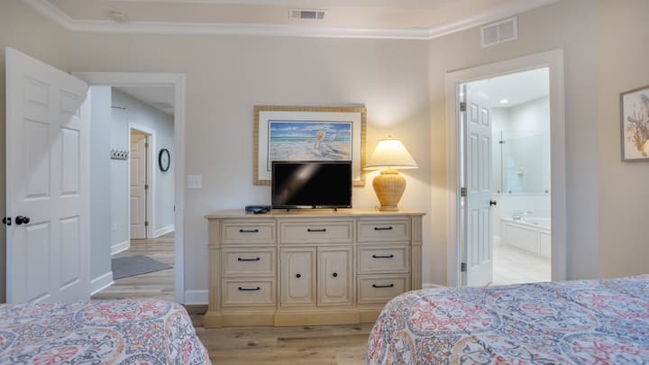 Televízor s plochou obrazovkou je umiestnený na priestrannej komode a je spárovaný s veľkou skriňou na jednoduché ukladanie.