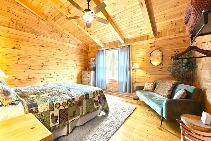 Spavaća soba s bračnim krevetom na gornjem katu i prostorom za sjedenje