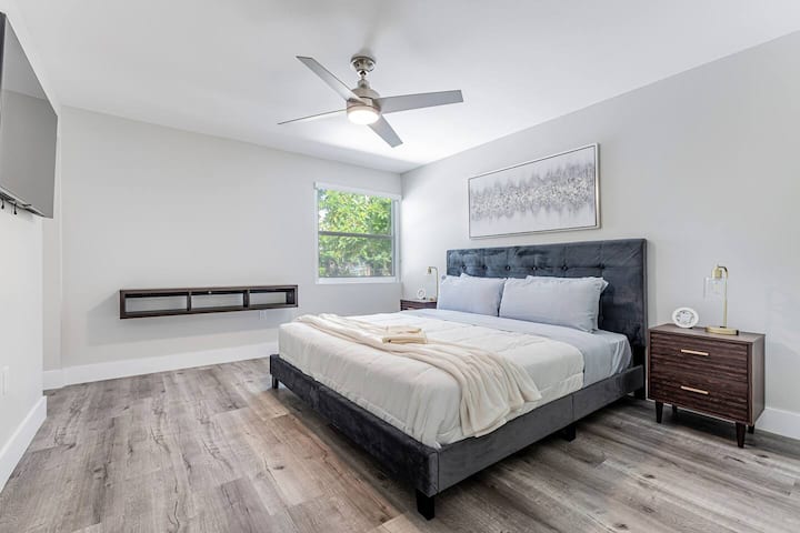 ผ่อนคลายในห้องนอนใหญ่ที่อบอุ่นด้านหลังด้วยผ้าปูที่นอนขนาดคิงไซส์หรูหราโต๊ะเขียนหนังสือลอยน้ำและสมาร์ททีวี