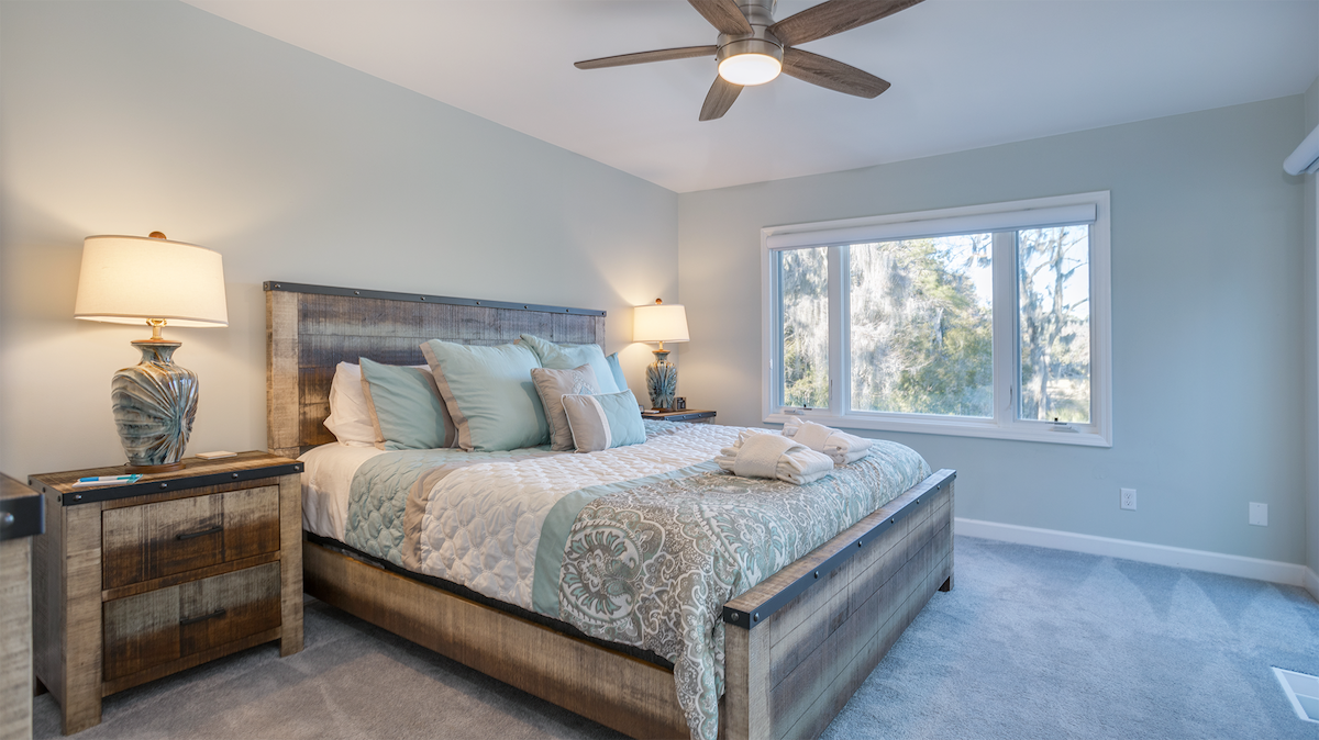 Тази приветлива основна спалня предлага спокойно и удобно място за почивка с меки крайбрежни тонове и плюшен килим.