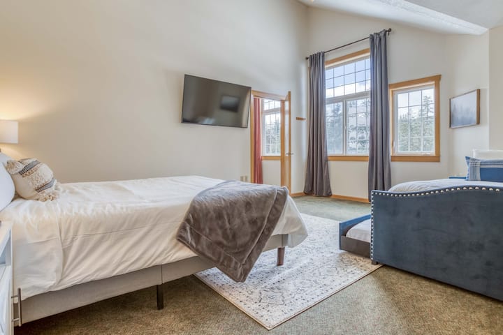 楼上的Chinook Lodge加大双人床卧室，带轮床灰色房间