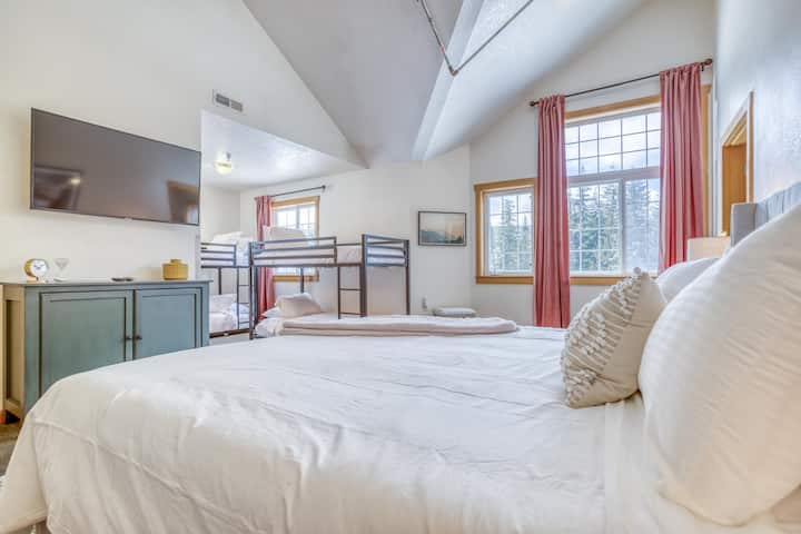 Chinook Lodge楼上的加大双人床卧室，配有粉色双层床房间