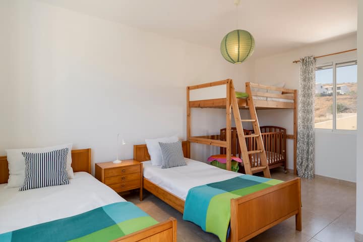 غرفة نوم بسريرين فرديين وسرير بطابقين