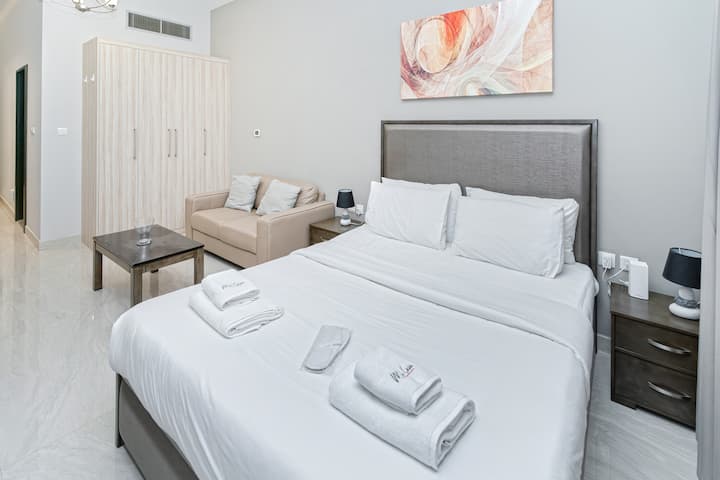 Queen size bed with linen, towels, slippers and blanket.