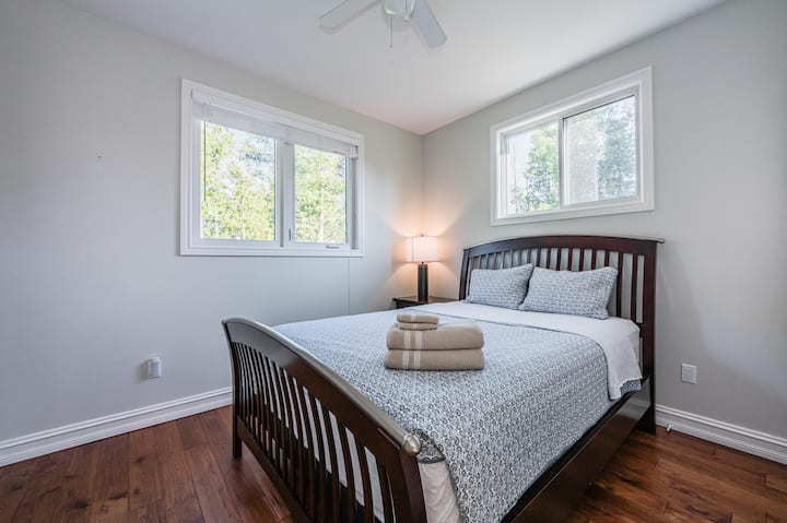 חדר האורחים הזה הוא מקום מפלט נעים ונקי, עם נוף ליער ושינה שלווה אחרי יום של הרפתקאות.