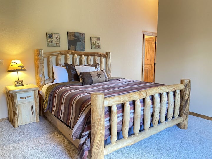 La spacieuse suite principale dispose de meubles en rondins personnalisés, d'un lit king size confortable, d'un accès à une terrasse privée et d'une salle de bains privative.