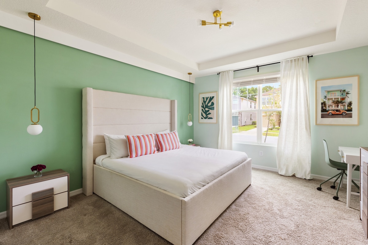 El dormitorio principal cuenta con una cama tamaño king, una mesa de trabajo, un televisor y un baño privado.