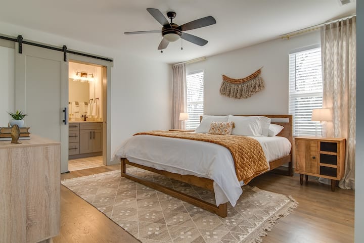 バスルームへのスライド式納屋のドアがあるモダンな寝室