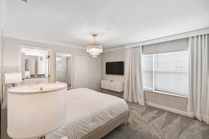 Experimenta la comodidad en este acogedor dormitorio lleno de luz natural, con una lujosa cama tamaño king con sábanas suaves, cortinas elegantes, alfombras ricas y un elegante candelabro, además de un televisor montado en la pared para tu entretenimiento.