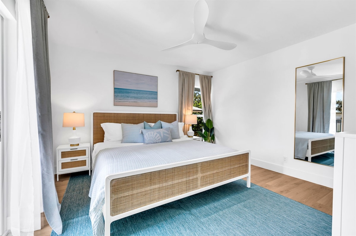 يقع السرير على سجادة سجادة داخلية/ خارجية زرقاء من طراز SAFAVIEH، وهناك طاولتان من طرفان أبيضان، ومصابيح زجاجية خزفية، وخزانة ملابس بيضاء حديثة مغطاة بمصباح سيراميك أزرق ناعم، ومنافذ USB، ورفوف أمتعة، وتلفزيون حريق 32بوصة، ومساحة للخزانة.