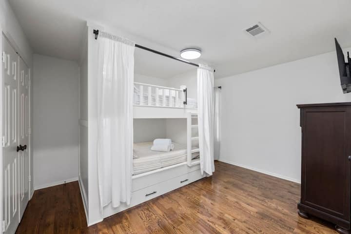 Separate bunk bedroom featuring built-in 2 Queen beds + Twin trundle, Smart TV, and spacious closet — a comfortable retreat for kids or adults alike.
