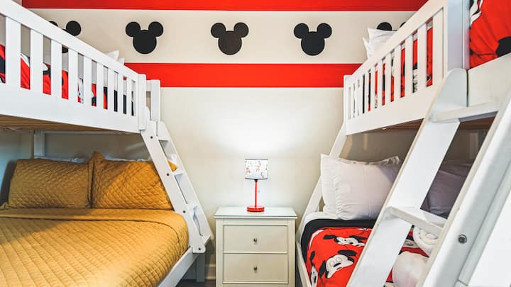Mickey Mouse-thema slaapkamer met twee stapelbedden voor speelse nachten.