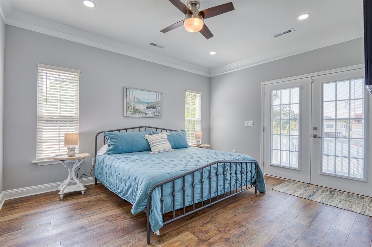 Dormitorio principal con cama tamaño king en el nivel principal con acceso al porche trasero