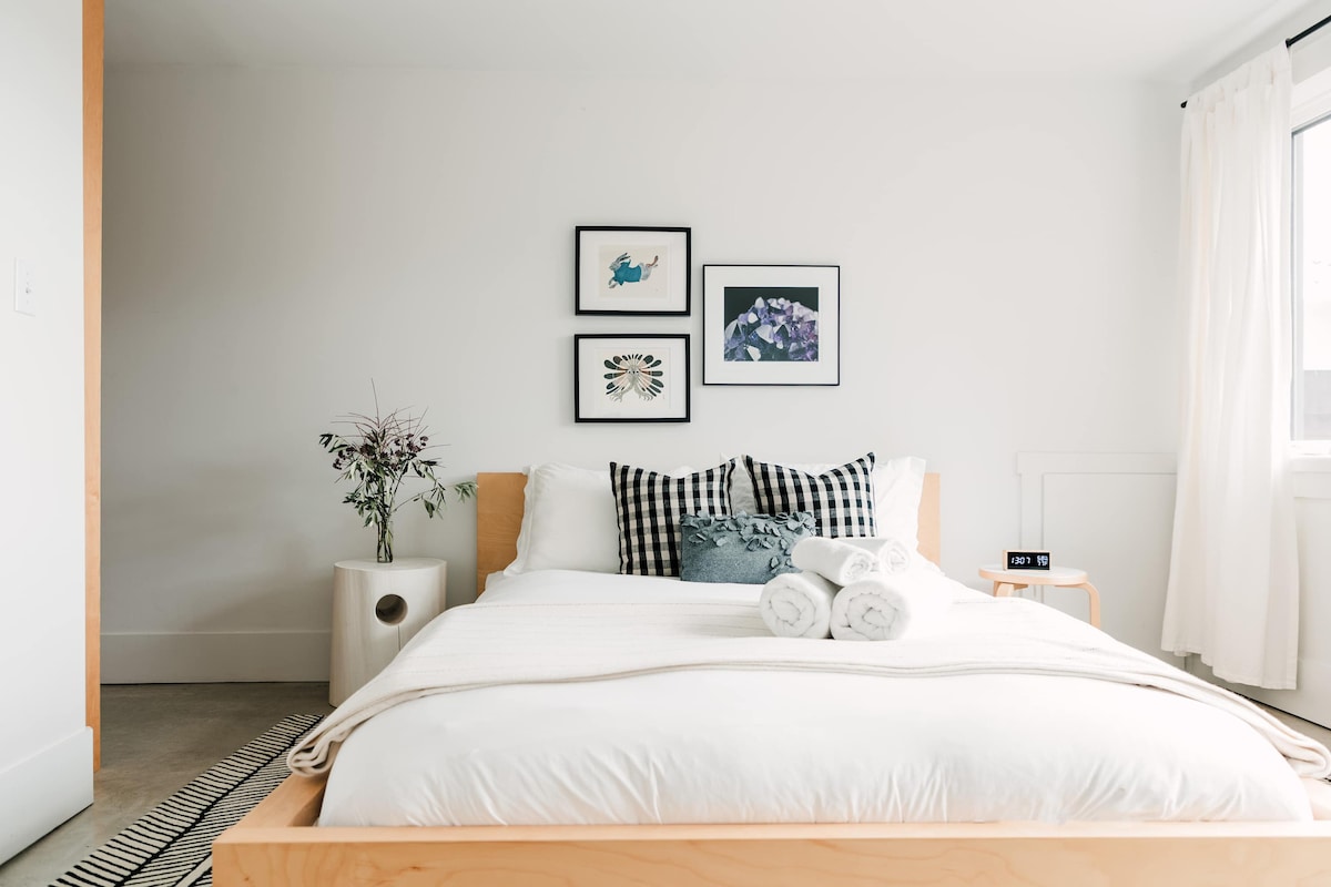 Upstairs bedroom 2 features a queen bed, full private ensuite, large window with view of front garden + living roof.