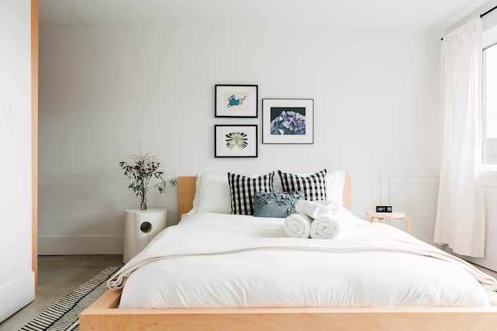 Upstairs bedroom 2 features a queen bed, full private ensuite, large window with view of front garden + living roof.