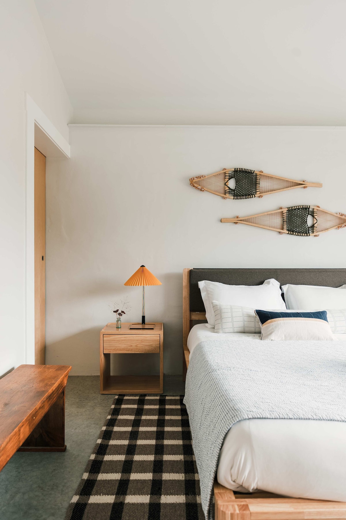 Primary bedroom on the main floor features a queen bed, double bunk bed + large window with a view of the front garden.