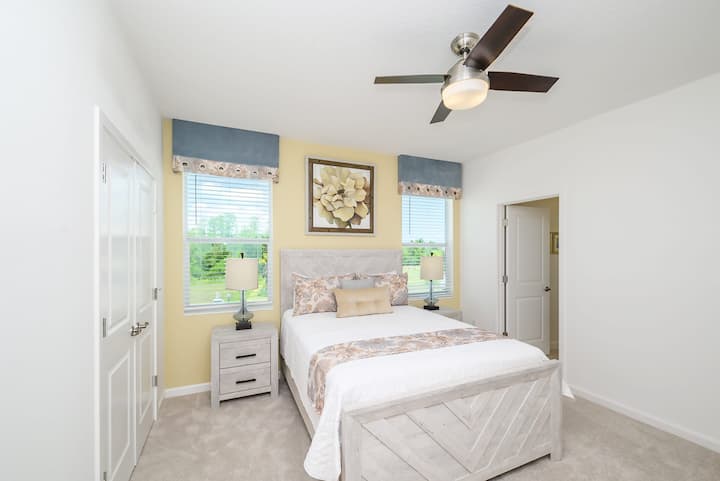 Dormitorio luminoso con una cama tamaño queen y decoración floral