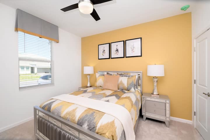 Dormitorio luminoso con una cama tamaño queen y vibrantes acentos amarillos