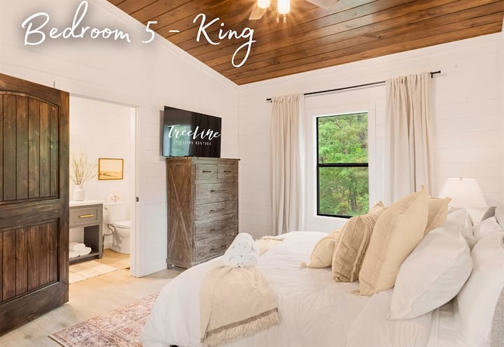 Acogedor dormitorio tamaño king con una lujosa cama, decoración acogedora y tranquilas vistas a la naturaleza desde la ventana.