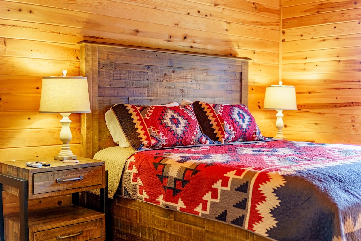 בחדר שינה 1 הראשי יש מיטת קינג סייז, שמיכת טלאים נעימה ורהיטים מוצקים