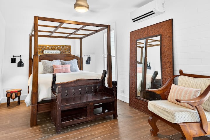 Drift into peaceful sleep in your elegant four-poster bed, surrounded by rich carved wood and cozy pink accents in this serene sanctuary.