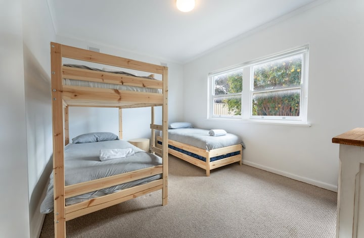 Una habitación versátil con una litera y una individual, ideal para niños o huéspedes adicionales.