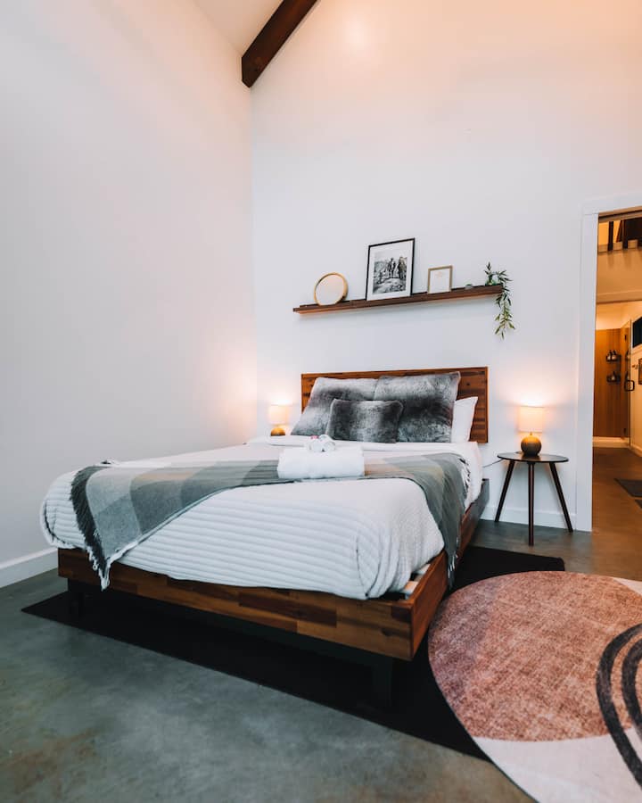 Main bedroom with queen bed, nightstands, and lamps.