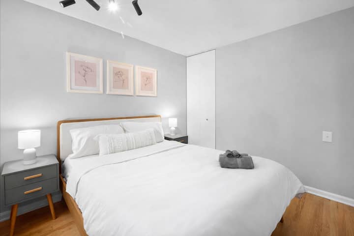 Habitación tranquila con cama queen, iluminación suave y pisos de madera noble