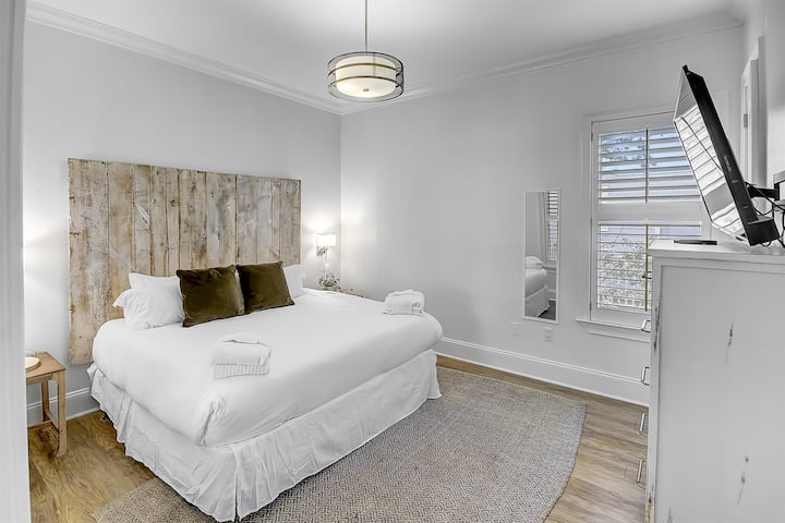 Dormitorio King del primer piso: esta habitación cuenta con una cómoda cama tamaño king, vestidor, armario y TV. Hay un baño completo adjunto con ducha a ras de suelo que se comparte con el resto de las habitaciones del primer piso.