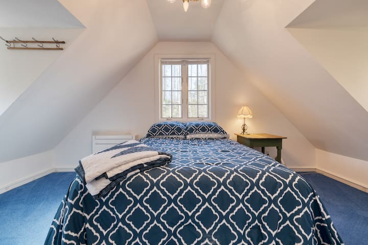 Guest cottage's bedroom features a queen bed.