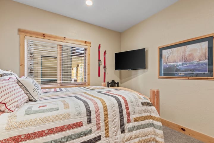 2: a sovrum med dubbelsäng och TV i rum. 