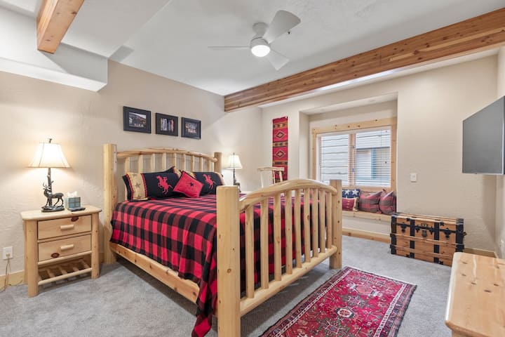 Huvudsovrum med dubbelsäng, takfläkt, TV och tillhörande badrum.