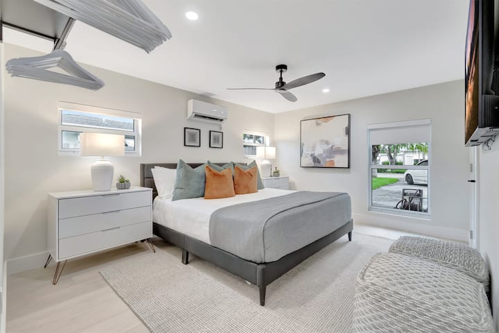 A well-equipped bedroom with a king bed, TV, dresser, hanging space, ceiling fan, and dedicated cooling for restful nights.