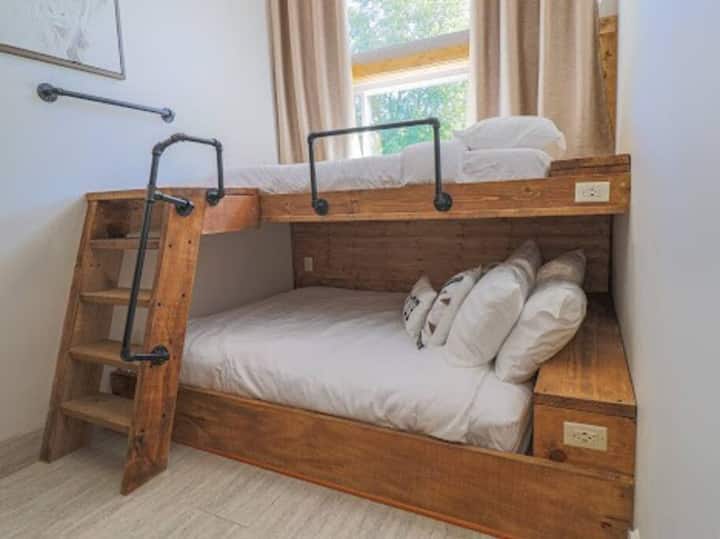 Une chambre pour 3 personnes. Lit queen size au fond et lits jumeaux extra longs sur le dessus.