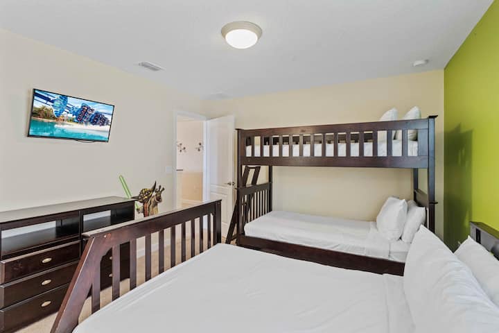 El dormitorio 4 ofrece una cómoda disposición con una cama doble y dos camas individuales, junto con un baño privado.