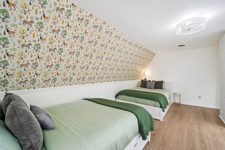 This upstairs bedroom is equipped with two queen beds and two twin trundle beds.