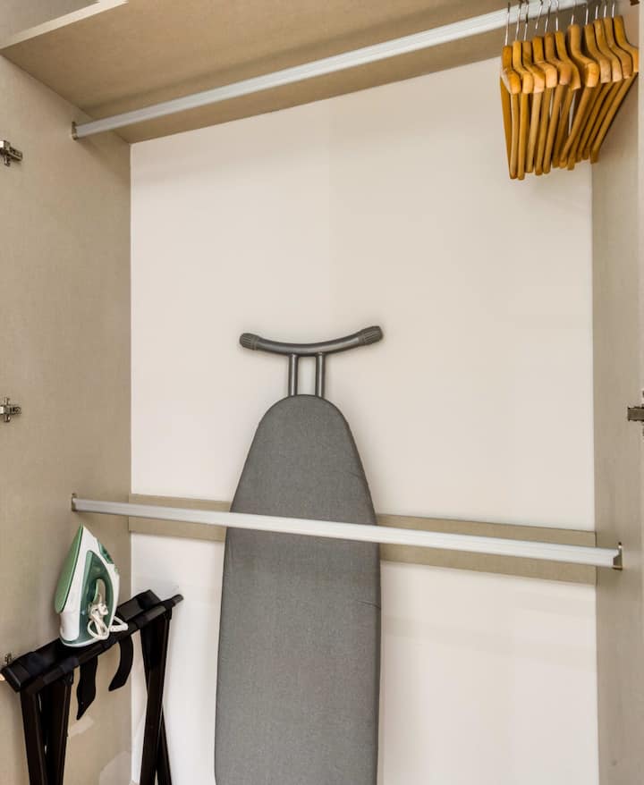 ארון עם קולבים, מגהץ וקרש גיהוץ.