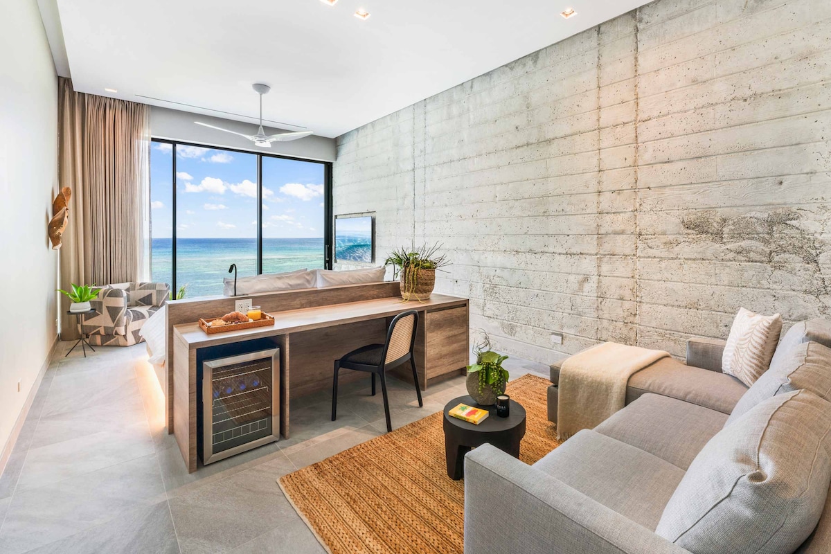 Suite 4 con cama tamaño king, vistas al mar, televisión, escritorio y silla con estación de bebidas. 