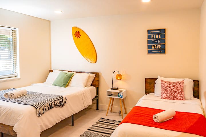 غرفة نوم 1 – سرير بحجم كوين + سريرين مفردين مع بياضات ناعمة ونوافذ مشرقة