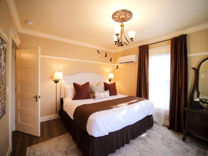 Očarujúca spálňa s bohatými tónmi a teplým osvetlením na pokojnú noc.