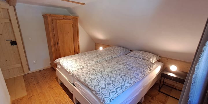 Dhomë gjumi në pyll në perëndim