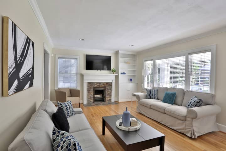 Елегантна и модерна всекидневна с ярка, просторна атмосфера. Бял диван, дървена подова настилка и много естествена светлина.