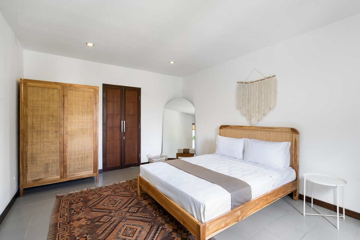 Vifaa vya asili vinavyotumiwa wakati wote, kama vile ubao wa kichwa wa rattan na kabati la nguo, huongeza joto na urudie mazingira ya kitropiki ya vila. 