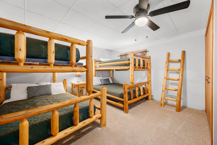 ¡Esta habitación con literas ofrece un encantador refugio con camas rústicas de madera y vibras juguetonas!
