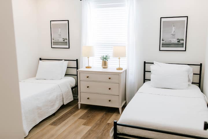 Chumba hiki cha kulala kina vitanda viwili vya starehe vya mtu mmoja, roshani na taa 