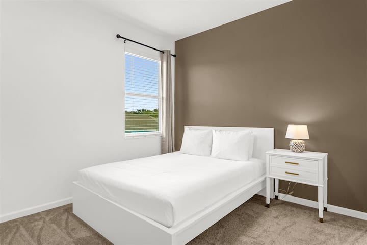 Komfortables Queensize-Doppelbett mit neutralen Tönen und natürlichem Licht