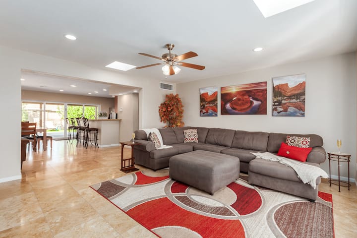 غرفة معيشة ذات تصميمية مشرقة في الطابق المفتوح تتميز بتلفزيون مريح وذكي.