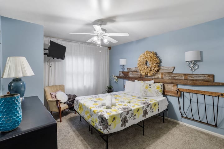 A reclaimed wood headboard and rustic wreath bring subtle farmhouse charm to this cozy bedroom.