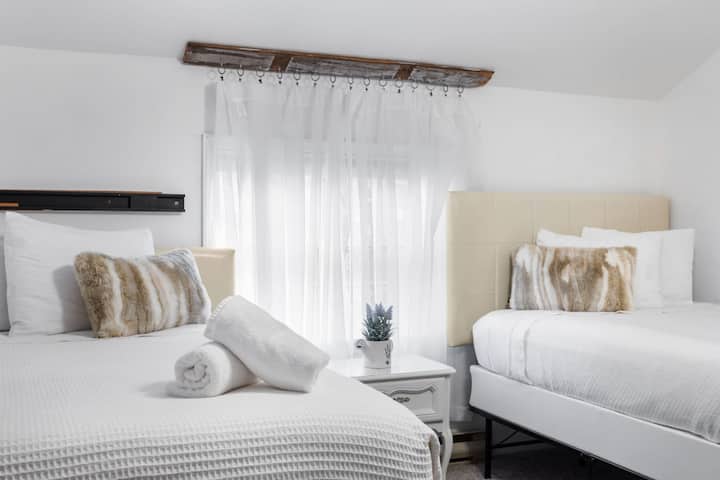 Sheer curtains drape from a rustic wood rod, allowing natural light to softly illuminate the room.